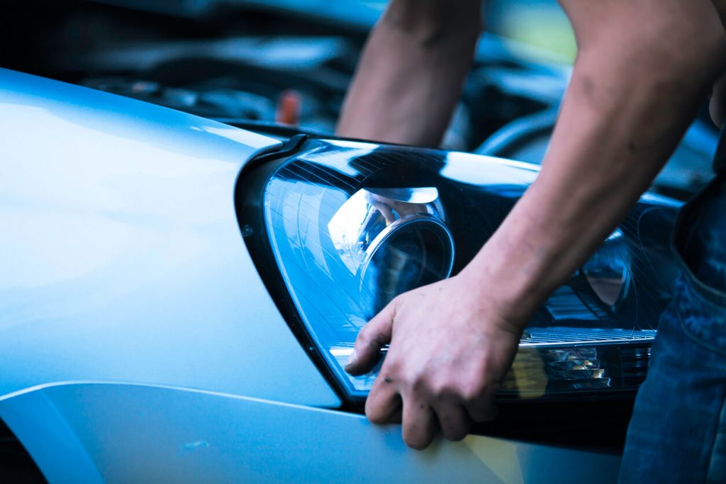 Used headlight is being installed by auto mechanic in Ontario
